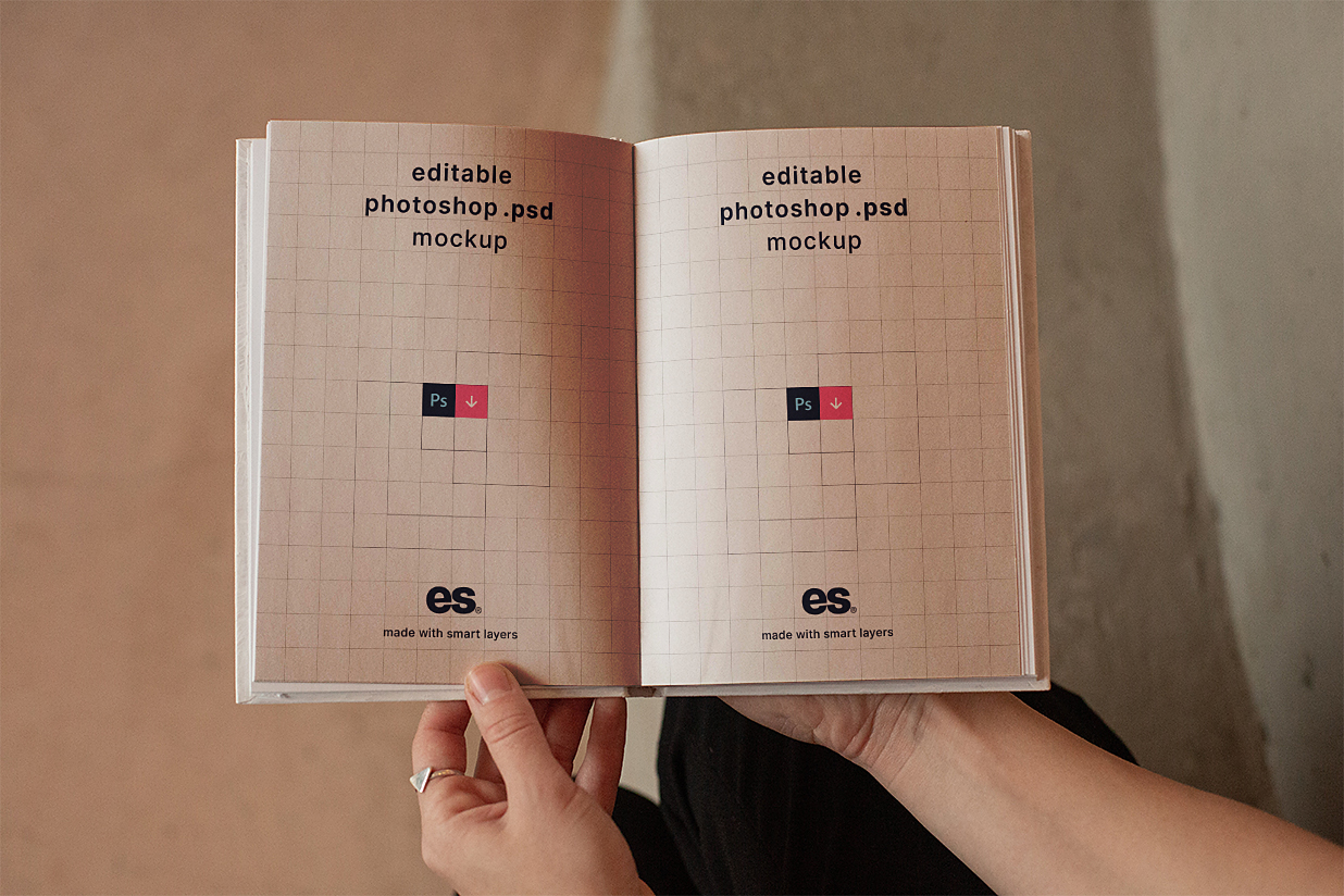 手持展开的精装书籍样机插图