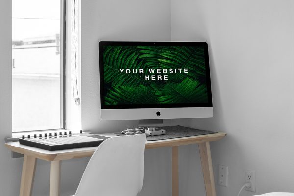 放在房间角落书桌上的iMac样机mockup